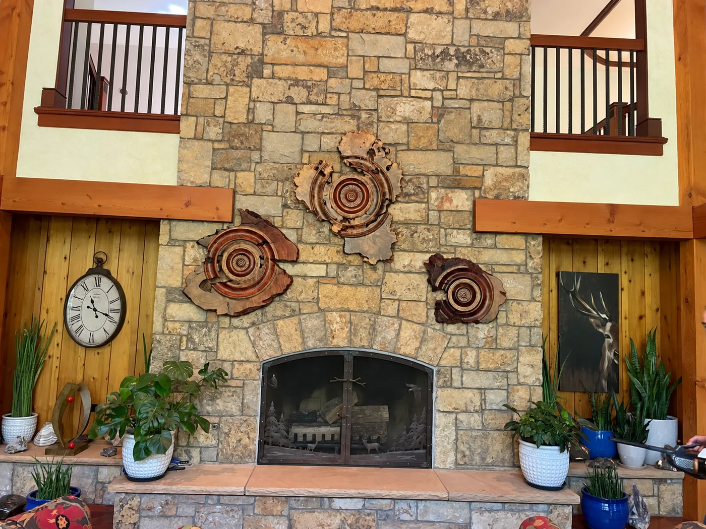 Three Barkby Woods sculptures installed above a stone fireplace